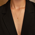A person wearing a black blazer and the Celestial Pendant Necklace Set, featuring a gold crescent moon and star pendant—an elegant gift for her.