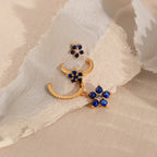 The Sapphire Flower Earrings Set features gold earrings with blue stones and diamonds, ideal for adding a touch of elegance to your jewelry collection.