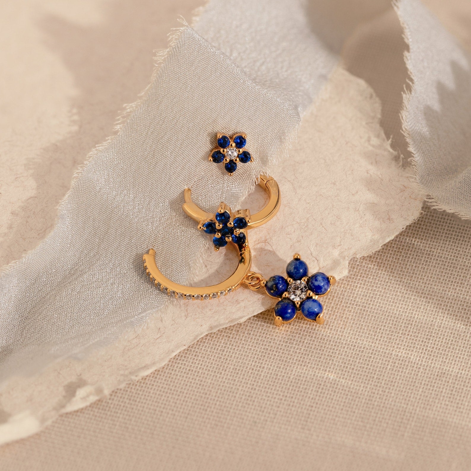 The Sapphire Flower Earrings Set features gold earrings with blue stones and diamonds, ideal for adding a touch of elegance to your jewelry collection.