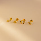 The Opal Cluster Studs Set features four gold flower earrings, two with pearl centers, displayed on a beige background—ideal for cartilage piercings or as elegant accents paired with opal cluster studs.
