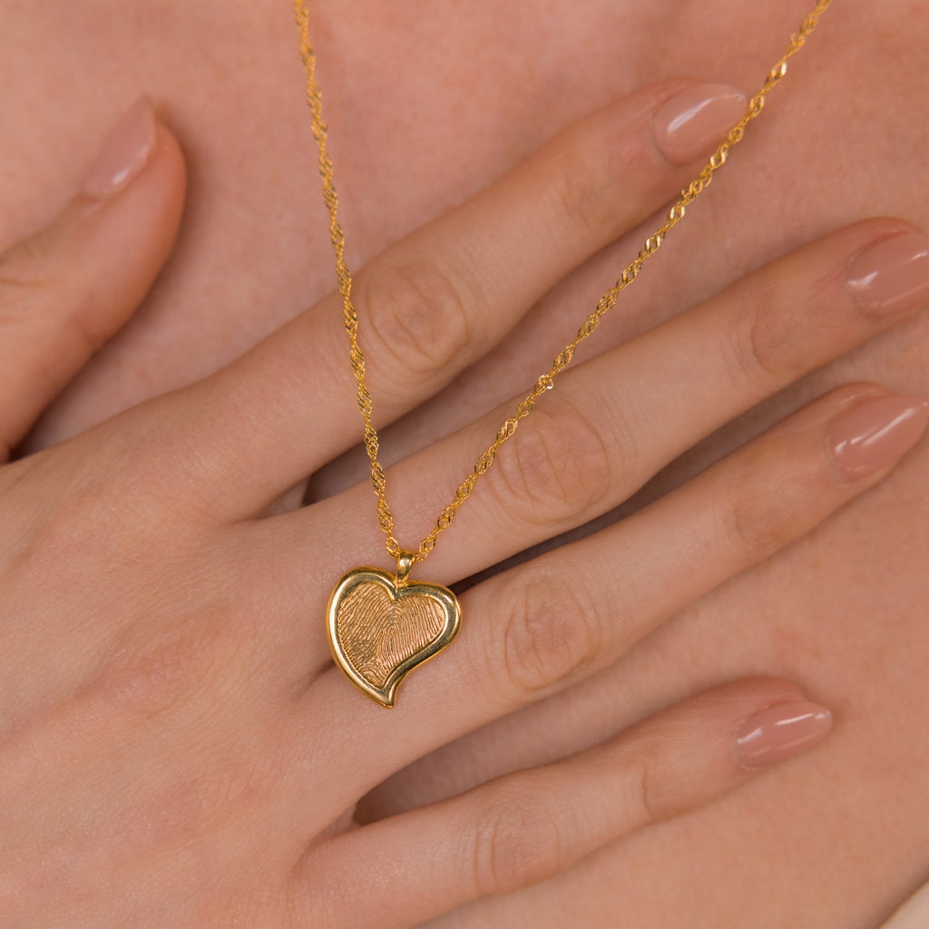 The Fingerprint Heart Necklace rests on a woman’s hand with nude nails—a meaningful memorial or thoughtful Mother’s Day gift.