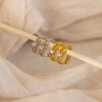 A close-up of the Diamond Infinity Hoops, paired with dainty earrings and romantic jewelry, captures timeless elegance.