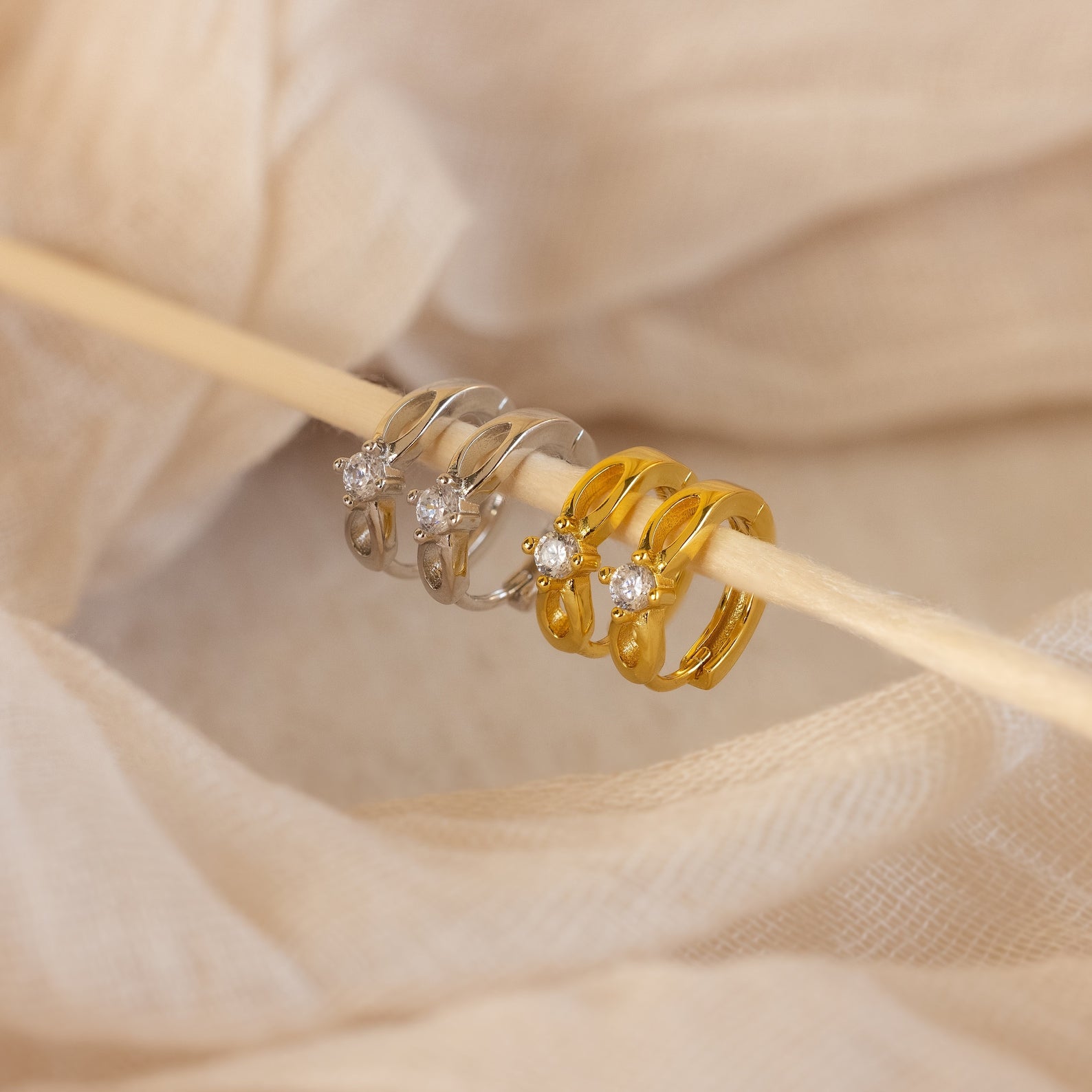 A close-up of the Diamond Infinity Hoops, paired with dainty earrings and romantic jewelry, captures timeless elegance.