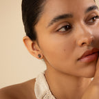 A woman with her hand on her chin, showcasing elegant Herkimer Agate Studs.