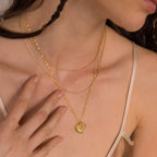 A woman wears a beige camisole and the Fingerprint Heart Necklace, a layered gold piece that makes a meaningful Mother's Day gift.