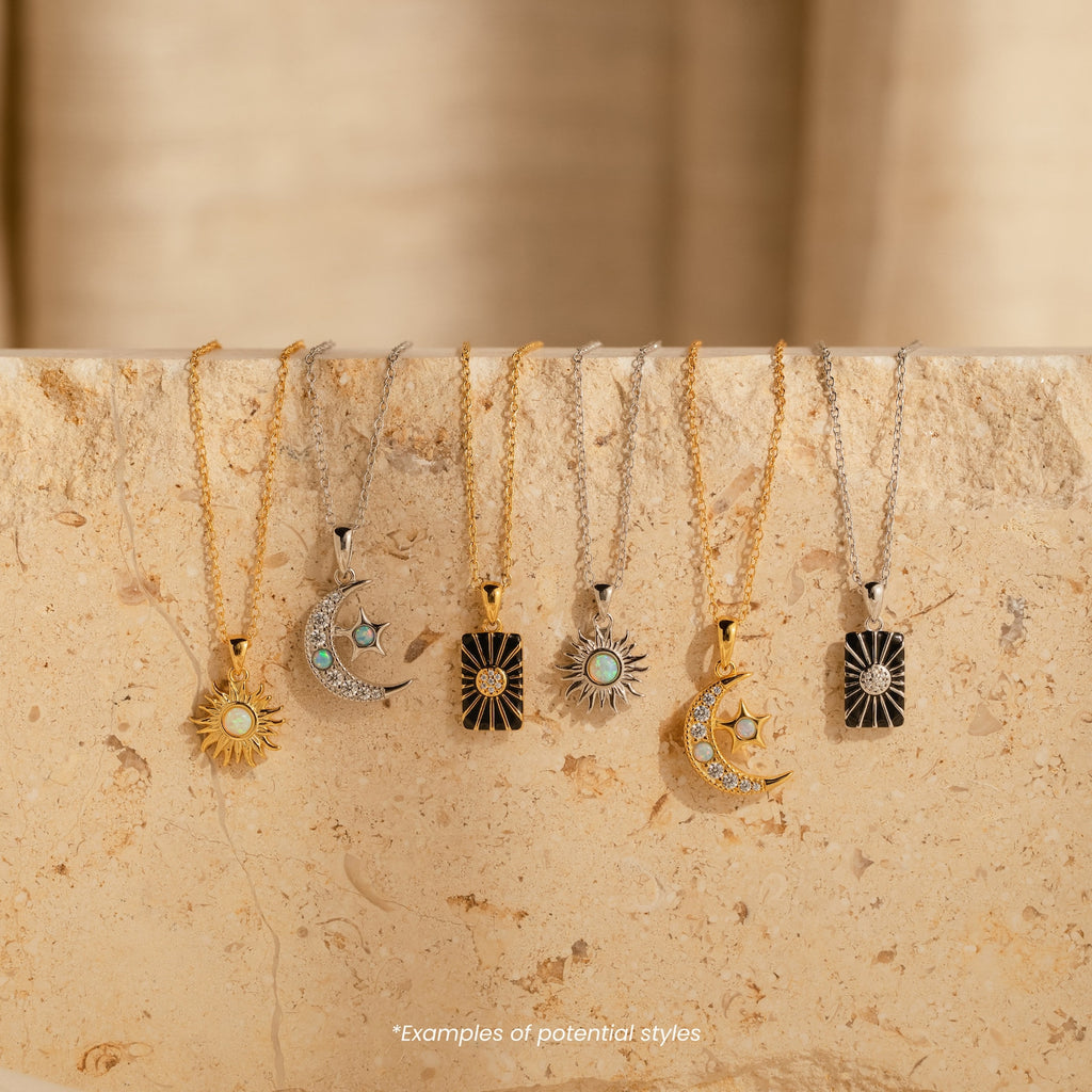 Six Mystery Necklaces with sun and moon pendants are displayed on a beige stone surface, each sophisticated piece capturing a celestial charm.