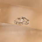Diamond Bezel Heart Huggies featuring five sparkling gemstones each are showcased against a neutral beige background.