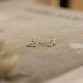 Close-up of the Trio Floral Marquise Studs, featuring delicate silver and small gemstones on a textured neutral surface—an elegant earring set inspired by classic diamond designs.