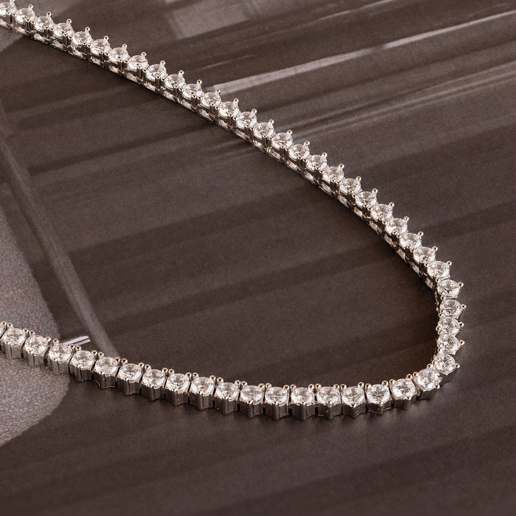 The 3-Prong Diamond Tennis Necklace & Bracelet Set in White Gold is displayed on a dark, glossy surface.