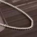 The 3-Prong Diamond Tennis Necklace & Bracelet Set in White Gold is displayed on a dark, glossy surface.