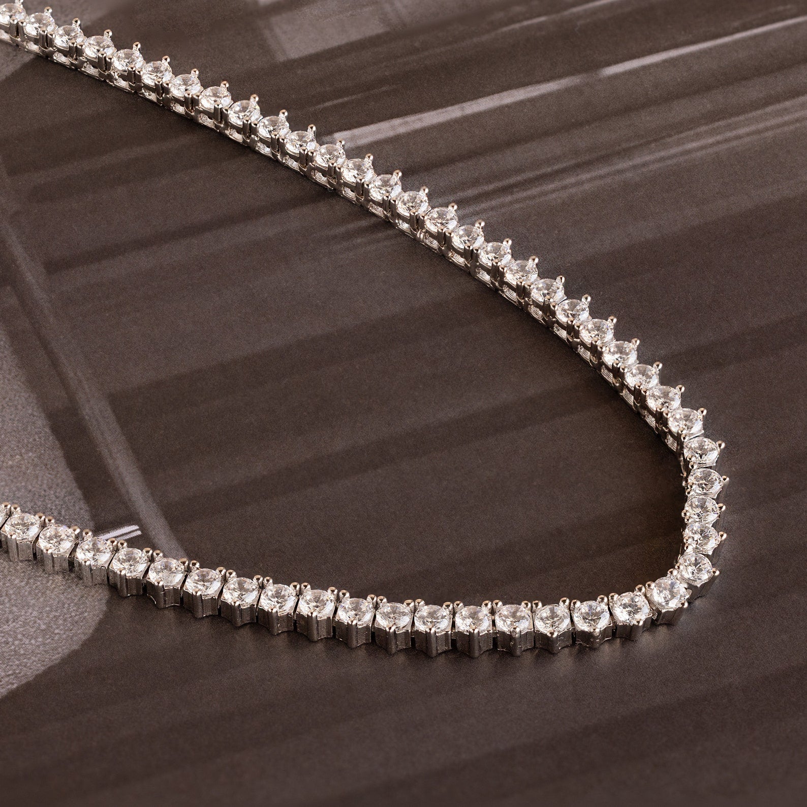 The 3-Prong Diamond Tennis Necklace & Bracelet Set in White Gold is displayed on a dark, glossy surface.