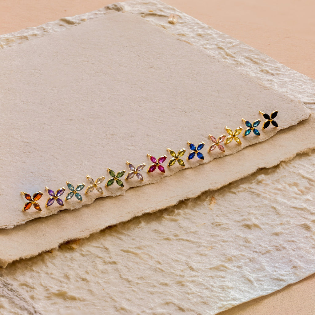 Birthstone Flower Studs displayed on textured, cream handmade paper, ideal for adding a personalized touch to any outfit.