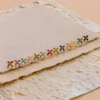 Birthstone Flower Studs displayed on textured, cream handmade paper, ideal for adding a personalized touch to any outfit.