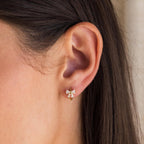 Close-up of model wearing Diamond Ribbon Bow Charm Huggie Earrings in Gold.