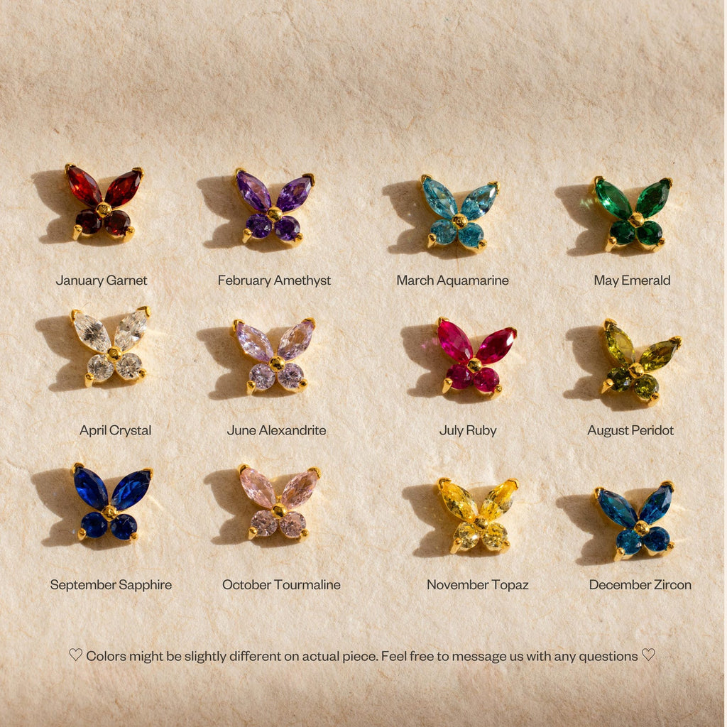 Twelve pairs of Butterfly Birthstone Studs, each symbolizing a birth month, are arranged in rows on a beige background—ideal for fans of gemstone earrings and butterfly jewelry.
