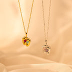 Two Footprint Birthstone Necklaces—one gold with colorful stones, one silver with clear stones—make a perfect parent and child jewelry set or can be worn as a personalized charm necklace.