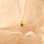 Footprint Birthstone Necklace with a pendant of two baby feet, each set with a birthstone—perfect parent and child jewelry—displayed on a soft beige background.