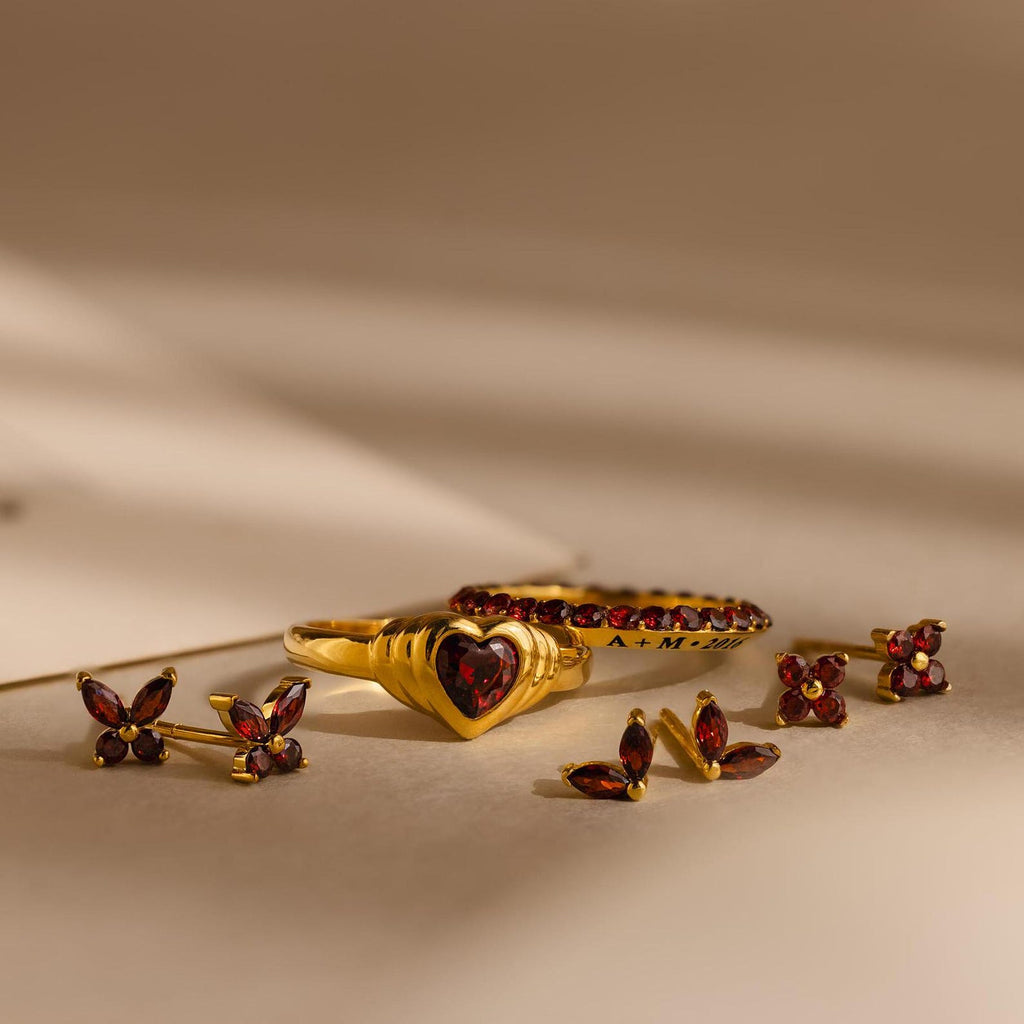 Ivy Flower Birthstone Studs with vibrant red gemstones are displayed on a neutral background with soft shadows.