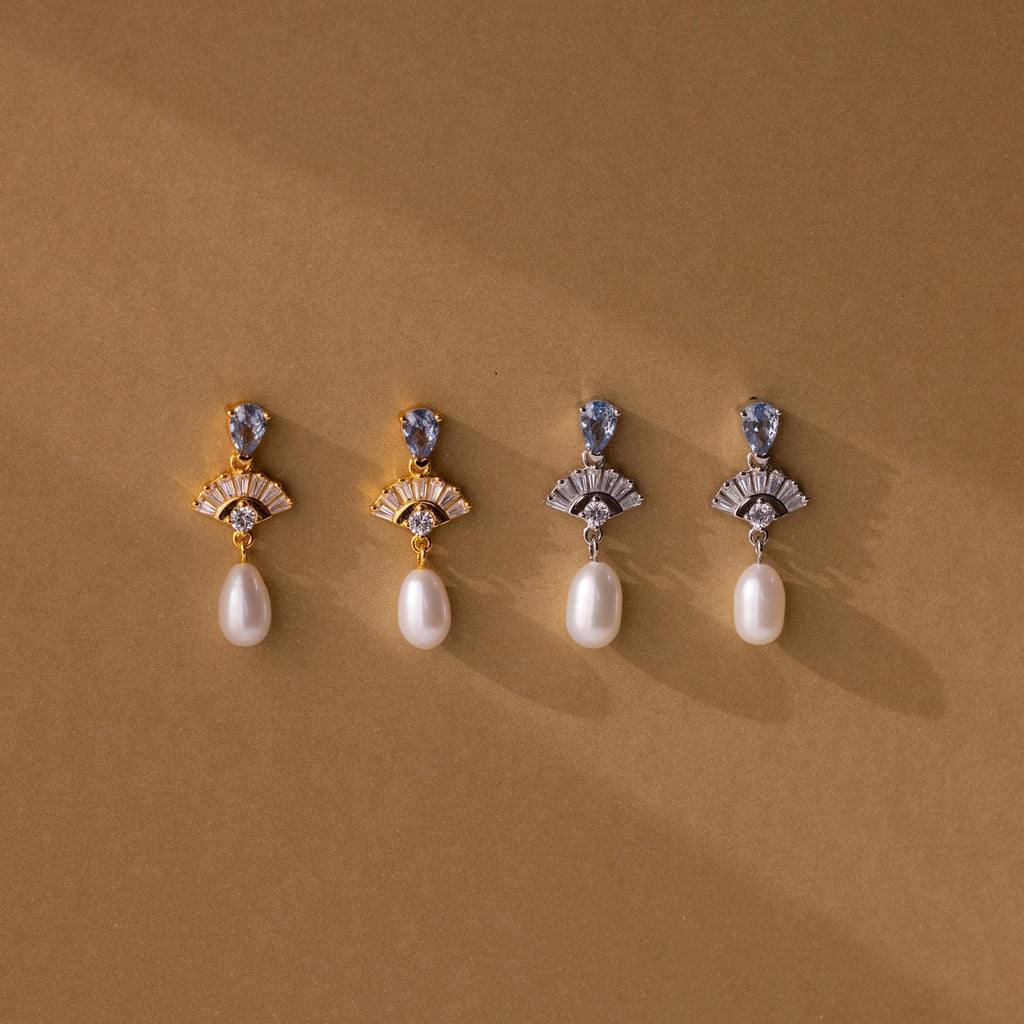 Four pairs of Aquamarine Pearl Drop Earrings—two gold, two silver—evoke vintage glamour, making perfect wedding jewelry and displayed elegantly on a brown background.