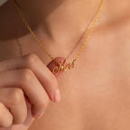 A person holds the Elegant Birthstone Name Necklace, featuring a custom pendant with "Mrs" written in delicate cursive.