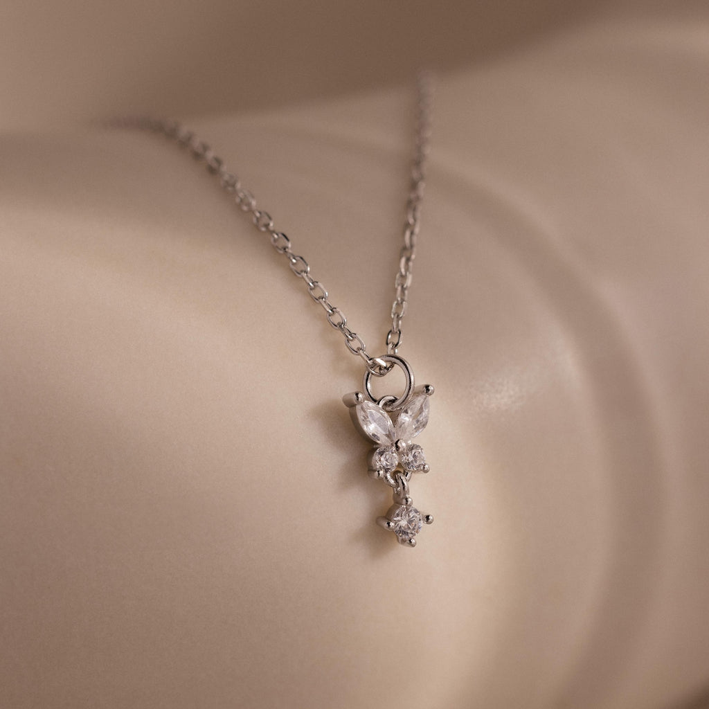 Close-up of the Diamond Butterfly Drop Jewelry Set in Sterling Silver, featuring a delicate diamond butterfly pendant resting gracefully on smooth, light-colored skin.