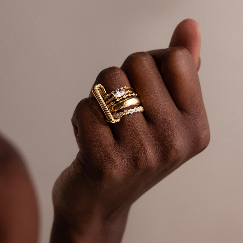 A hand displays the Multipurpose Pave Link Clasp Set in 18K Gold, highlighting its elegant style against a neutral background.