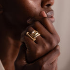 A close-up of a dark-skinned hand near the chin showcases effortless styling with the Multipurpose Pave Link Clasp Set—18k gold rings stacked for a modern look.