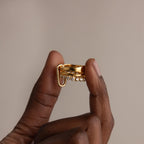 Hand holding the Multipurpose Mixed Metal Clasp Set featuring a unique dangling detail, perfect for stylish stacking, against a neutral background.