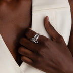 A hand with a Multipurpose Mixed Metal Clasp Set, ideal for stacking, rests on the chest against a white sleeveless garment.