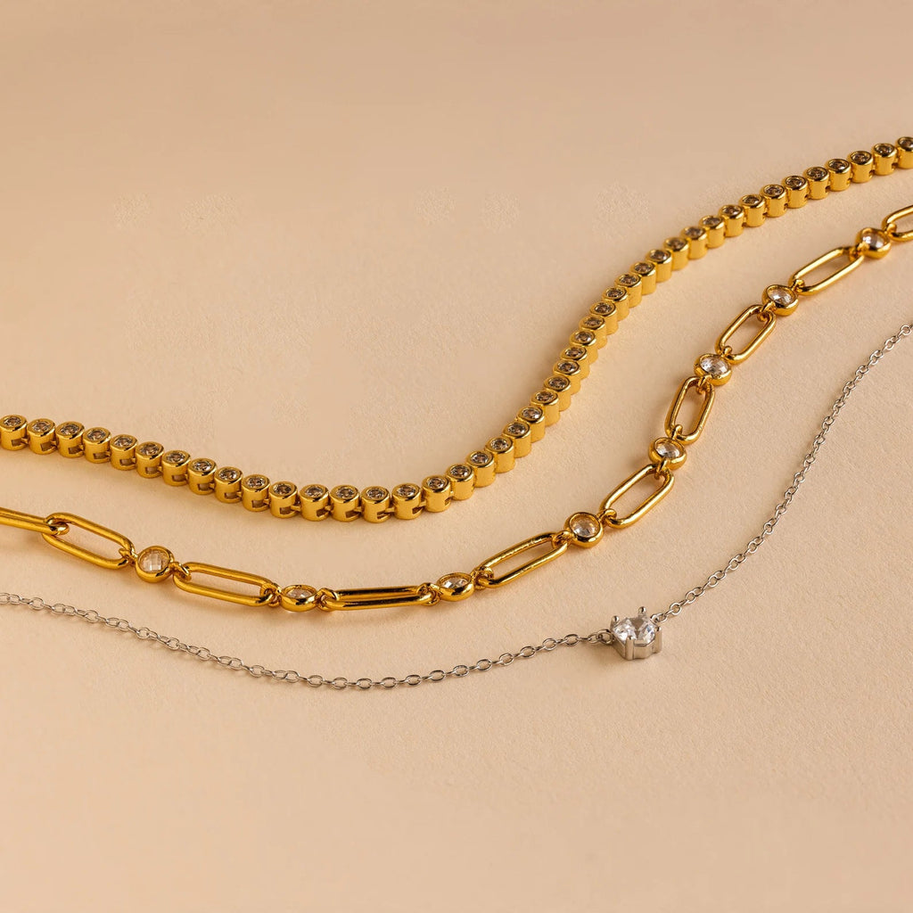 The Corporate Gift Box features three necklaces on a beige background: two gold chains and one silver chain with a small pendant—an elegant, curated choice perfect for personalized gifting.