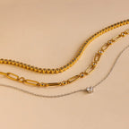 The Corporate Gift Box features three necklaces on a beige background: two gold chains and one silver chain with a small pendant—an elegant, curated choice perfect for personalized gifting.