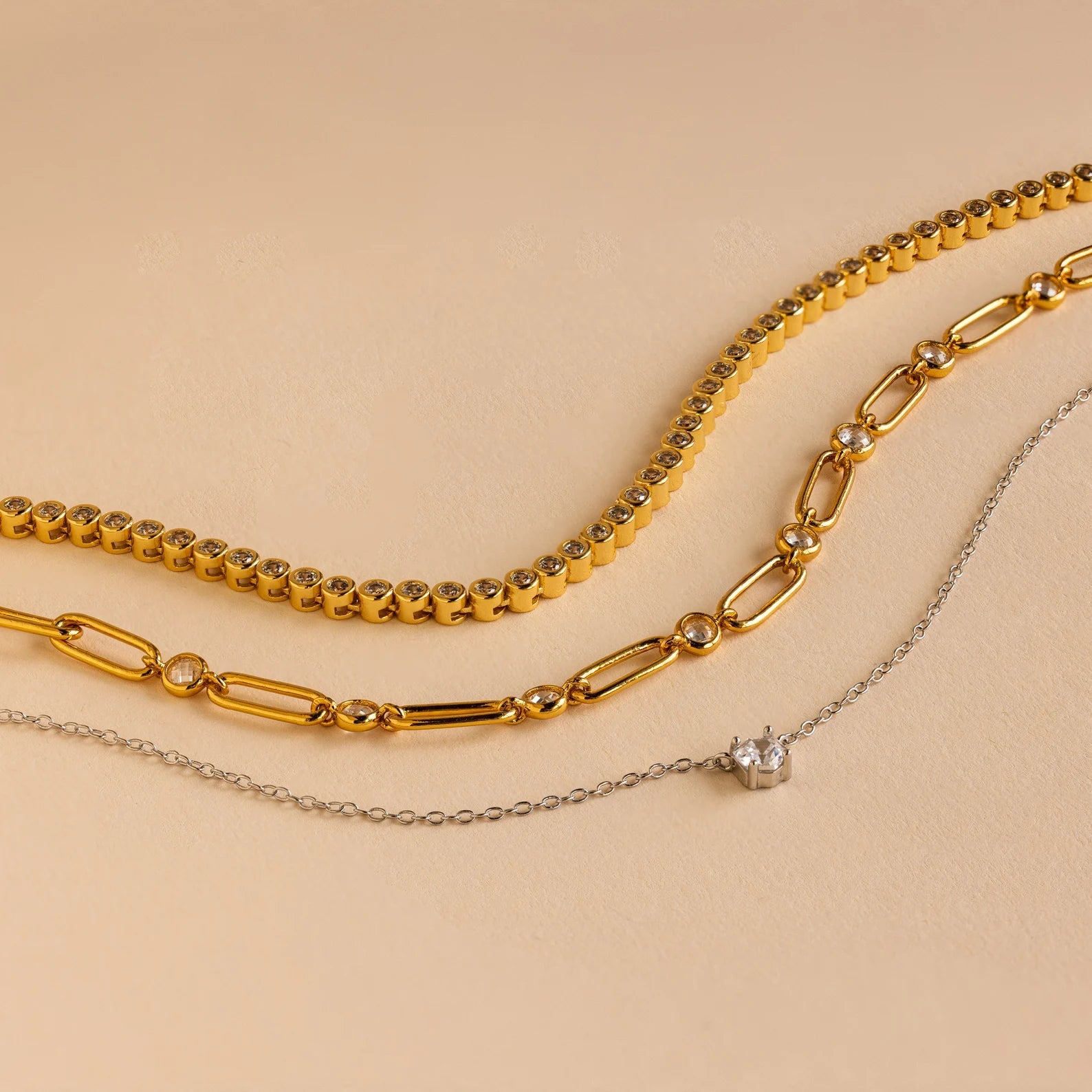 The Corporate Gift Box features three necklaces on a beige background: two gold chains and one silver chain with a small pendant—an elegant, curated choice perfect for personalized gifting.