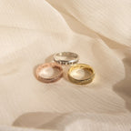 Three engraved Add-On Listing rings with fingerprint designs on textured cream fabric, highlighting unique personalization options for your custom order.