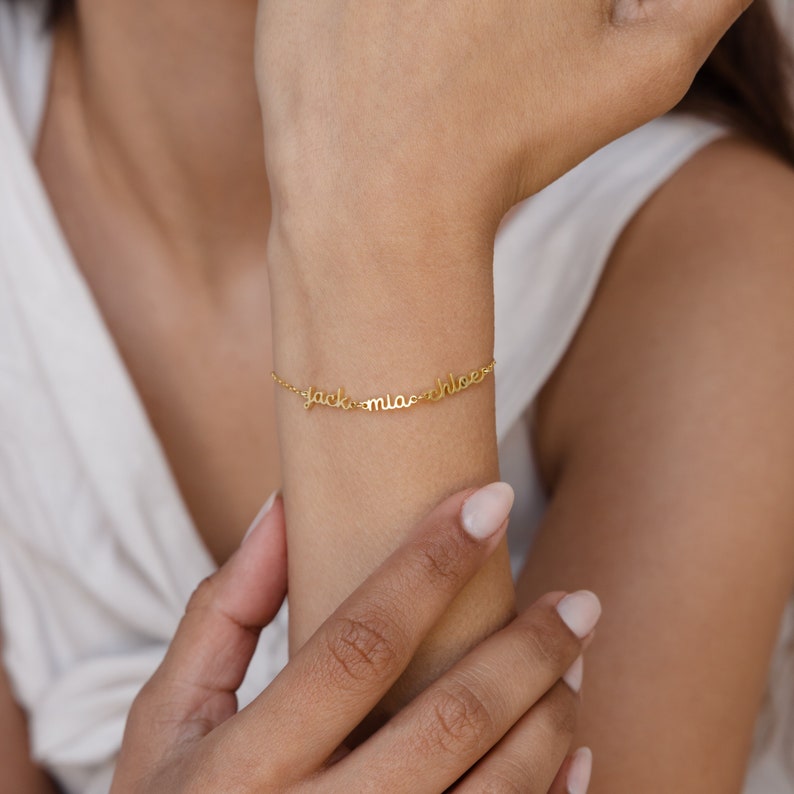 Add-On Listing: Gold bracelet with custom cursive names shown on a woman’s wrist—ideal for personalization or as a thoughtful addition to any custom order.