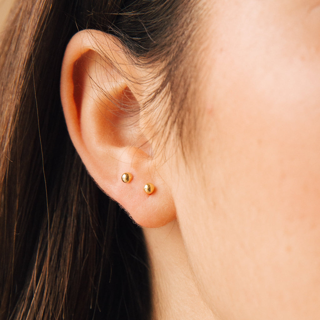 A close-up of an ear wearing the Nora Duo Studs in Sterling Silver—two minimalist studs in adjacent piercings, perfect for everyday style.