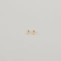 The Tiny Cross Studs are delicate stud earrings with small gold cross charms, shown against a plain white background.