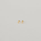 The Tiny Cross Studs are delicate stud earrings with small gold cross charms, shown against a plain white background.