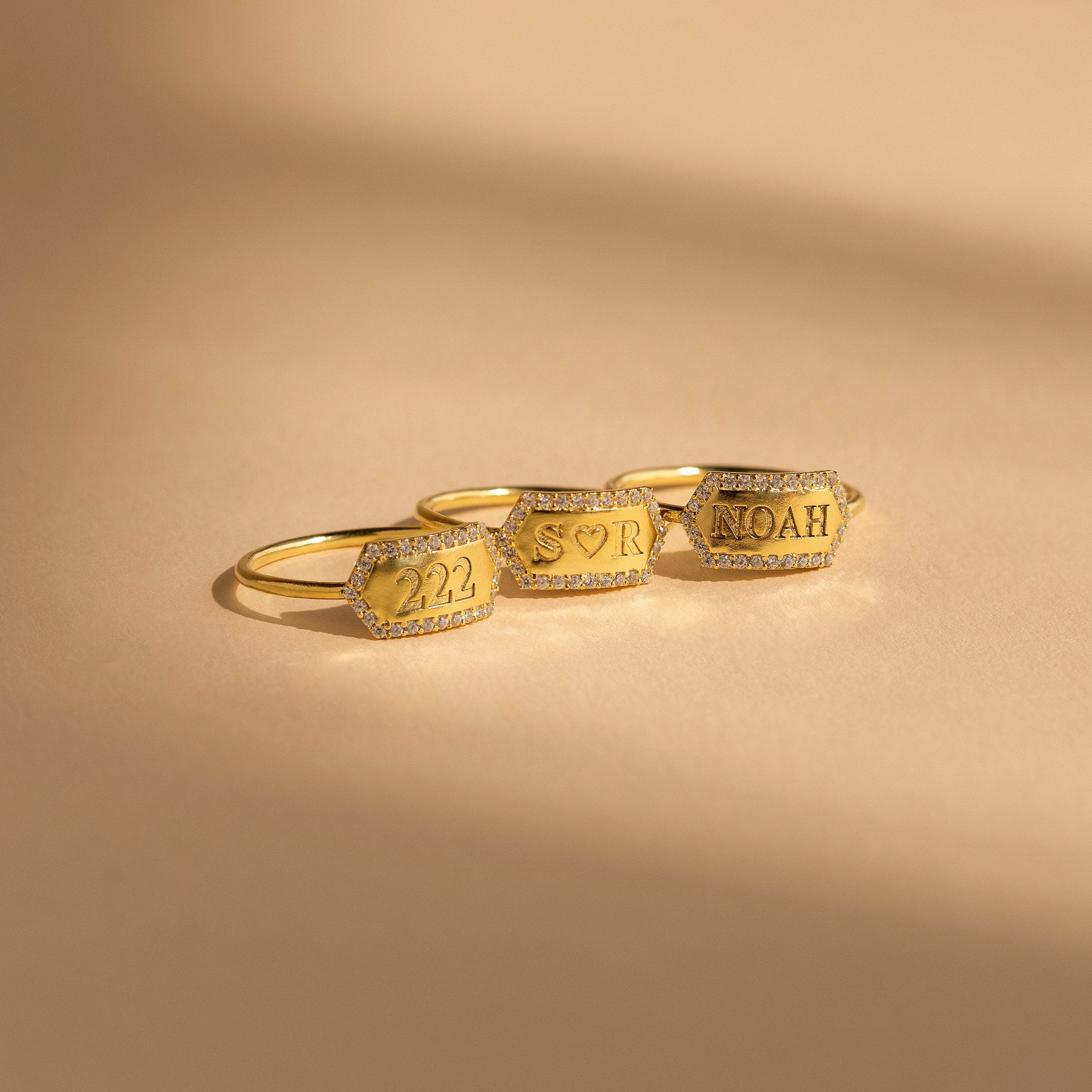 The Custom Pave Hexagon Ring rests on a beige surface—a perfect personalized minimalist ring with a modern geometric design.