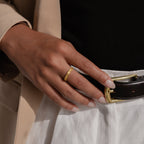 Gold engraved filigree ring shown on model’s hand styled with high-waisted trousers and a tailored beige blazer.