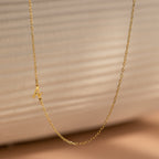 The Venice Sideways Initial Necklace features a delicate gold chain with a small sideways M pendant, perfect for lovers of subtle, personalized jewelry and beautifully showcased against a neutral background.