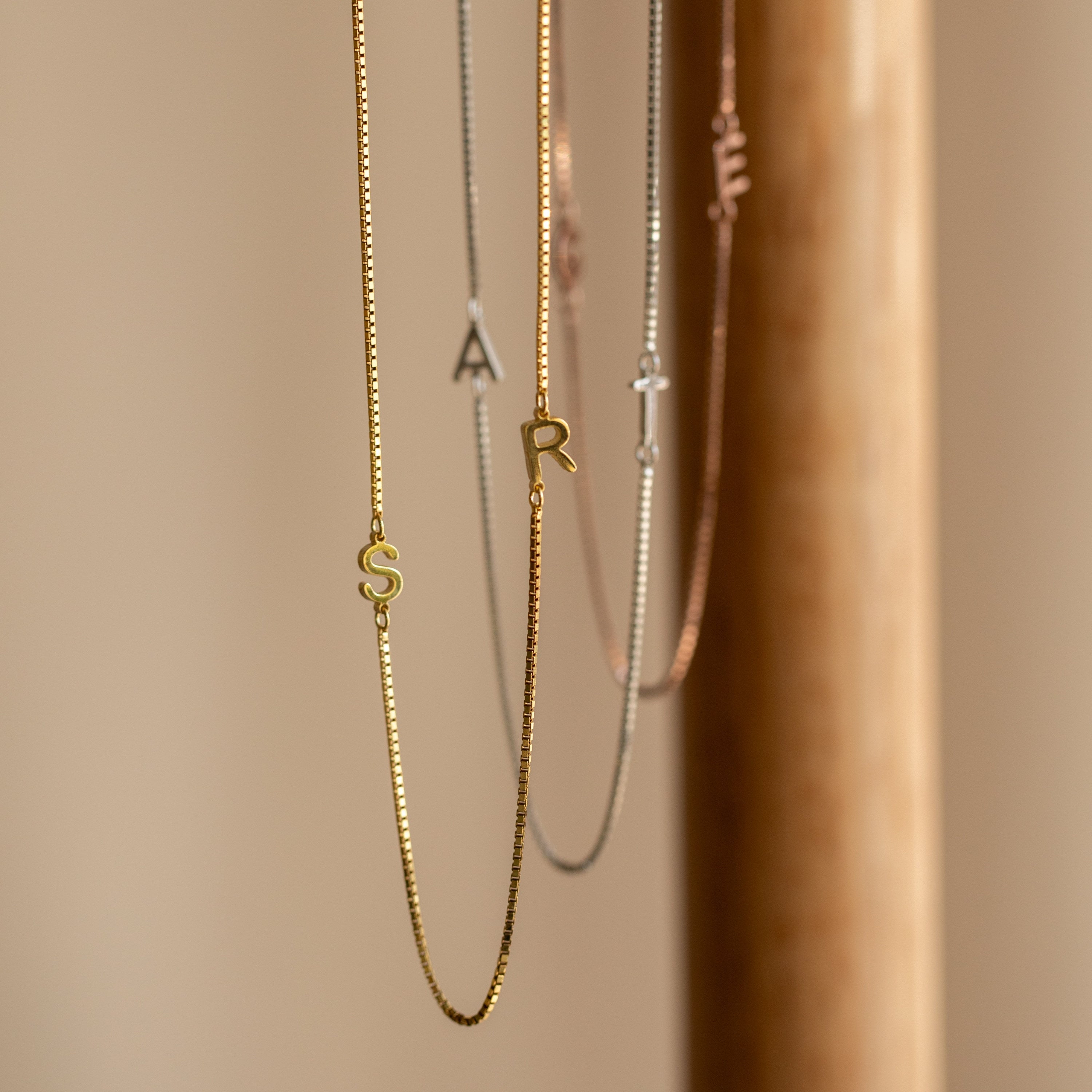 Gold and silver Duo Initial Necklace in Box Chain featuring S, A, and R letter charms, elegantly displayed on a neutral background. Personalize your style with this perfect accessory.
