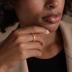 Model wearing a delicate gold filigree ring with vintage details, styled with neutral makeup and natural lighting.