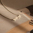 Retro Name Necklace in Box Chain showcased on a gently lit beige surface—an elegant, personalized jewelry piece ideal for expressing your distinct style.