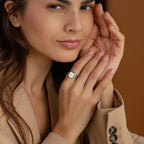 A woman in a beige blazer displays the Lucky Number Signet Ring, her hands gently near her face—an ideal statement piece for anyone who loves personalized engraving.