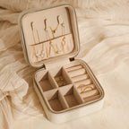 Open the Mystery Jewelry Box to reveal handpicked necklaces, rings, and earrings beautifully displayed on a soft beige fabric background.