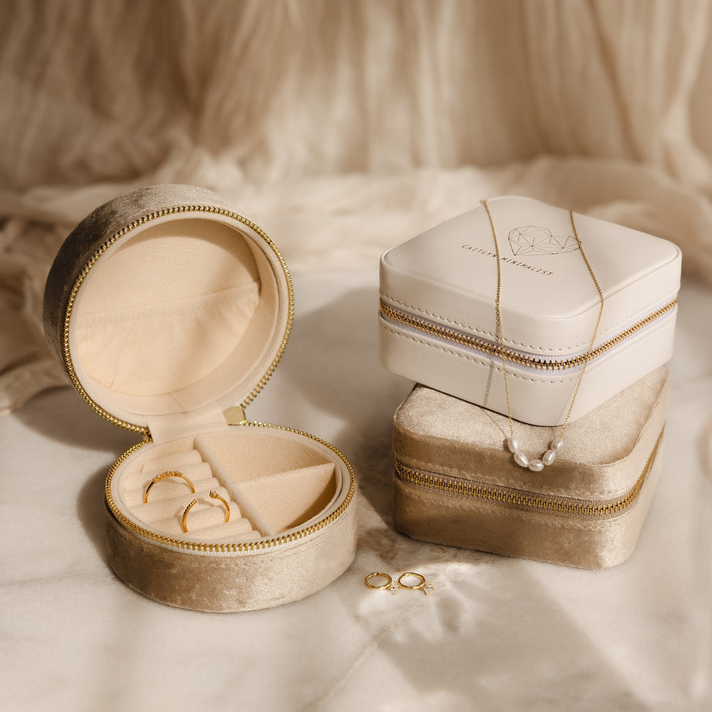 The Mystery Jewelry Box unveils handpicked pieces—gold rings, a gold necklace, and a pearl necklace—beautifully arranged on soft beige fabric.