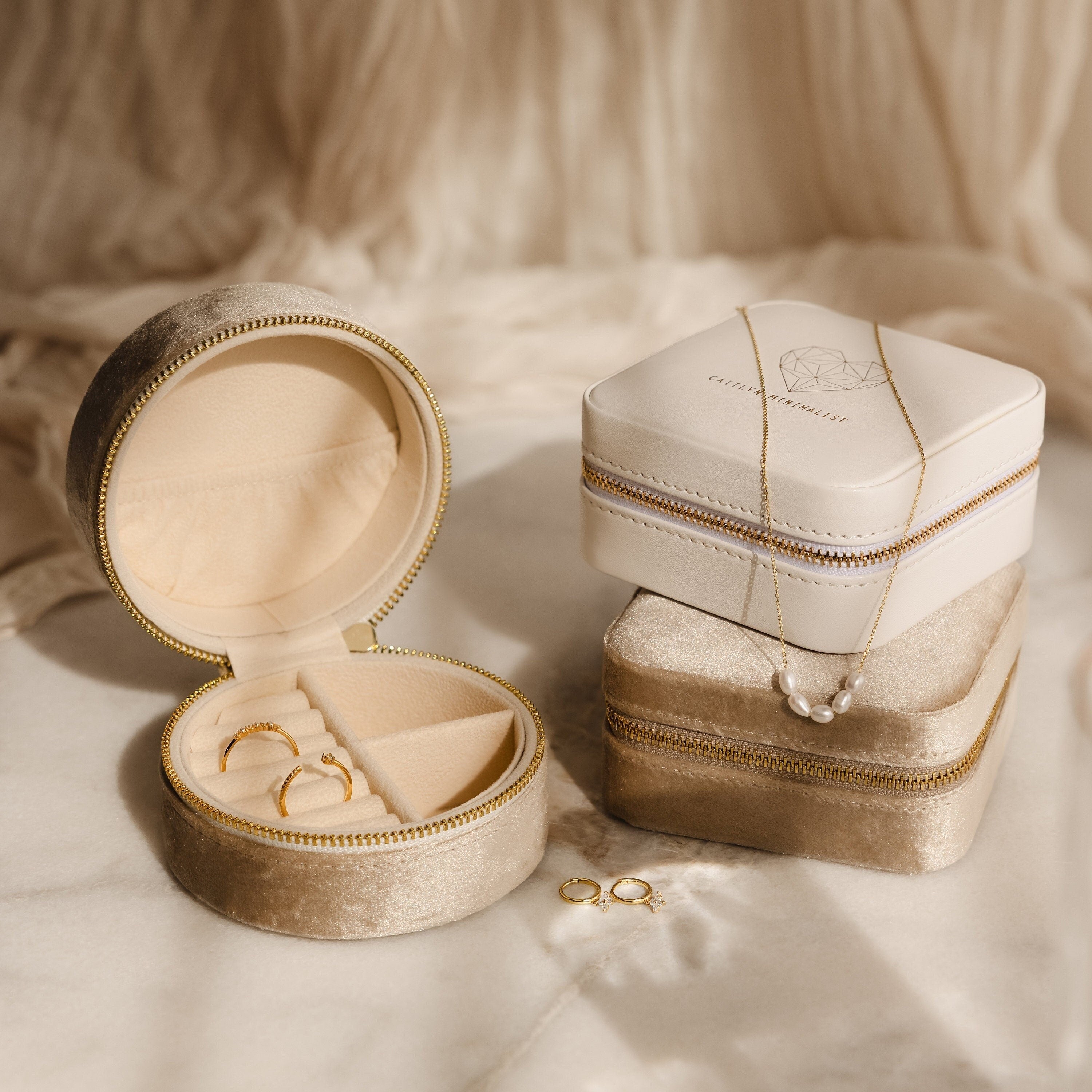 The Mystery Jewelry Box unveils handpicked pieces—gold rings, a gold necklace, and a pearl necklace—beautifully arranged on soft beige fabric.