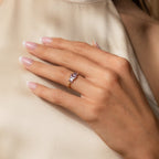 A hand adorned with the Art Deco Birthstone Ring, showcasing a sparkling baguette-cut stone.