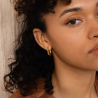 Woman with curly hair wears Twisted Link Hoops, styled from the side against a neutral background.