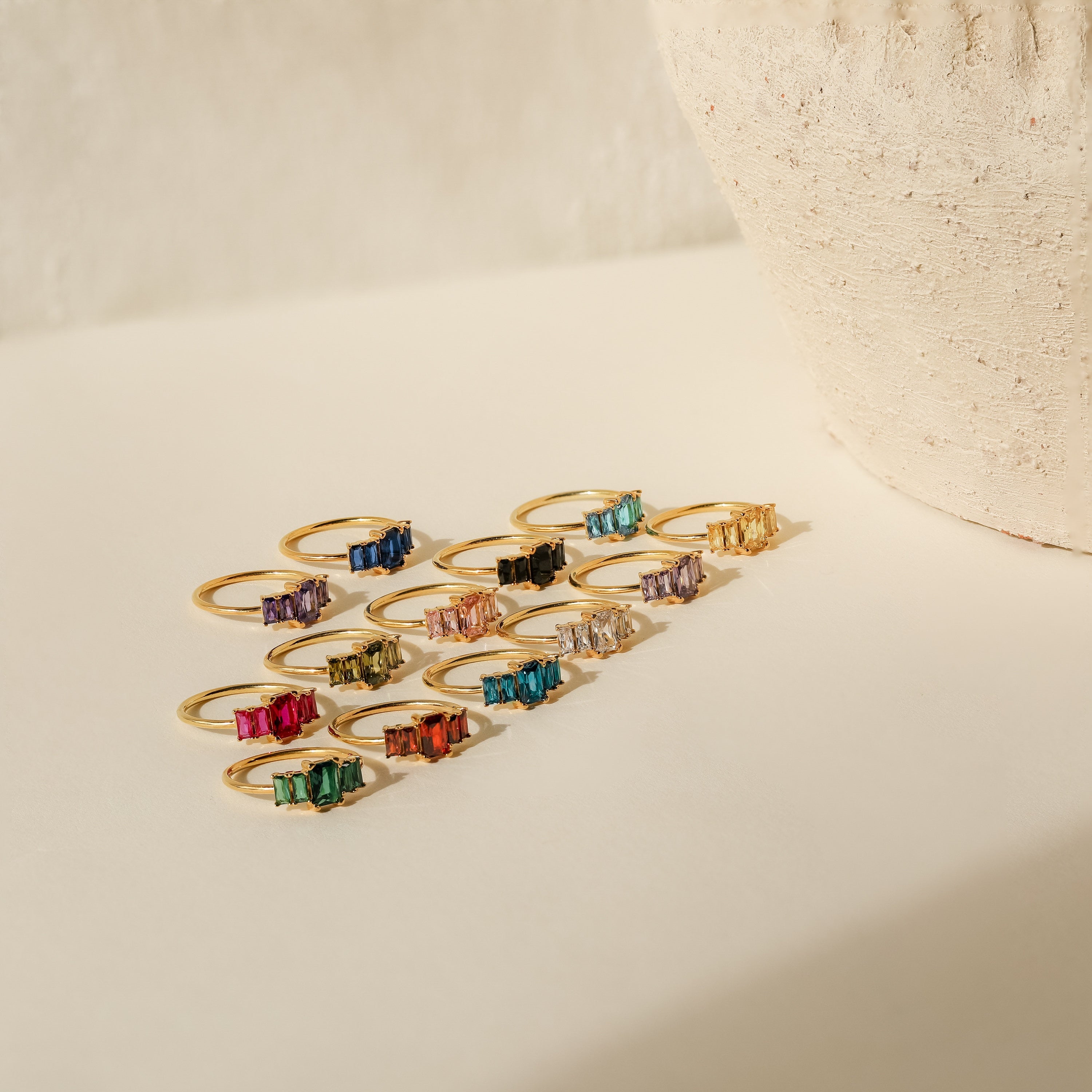 The Art Deco Birthstone Ring features vintage charm with a unique baguette-cut gemstone, available in various colors.